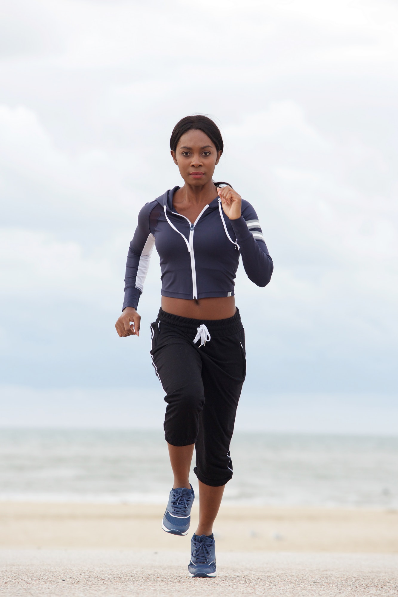 Full body healthy african american woman running at the beach
